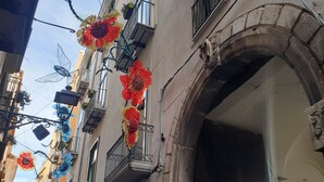 Une rue étroite bordée d’immeubles dotés de balcons et d’une porte d’entrée en arc de cercle.