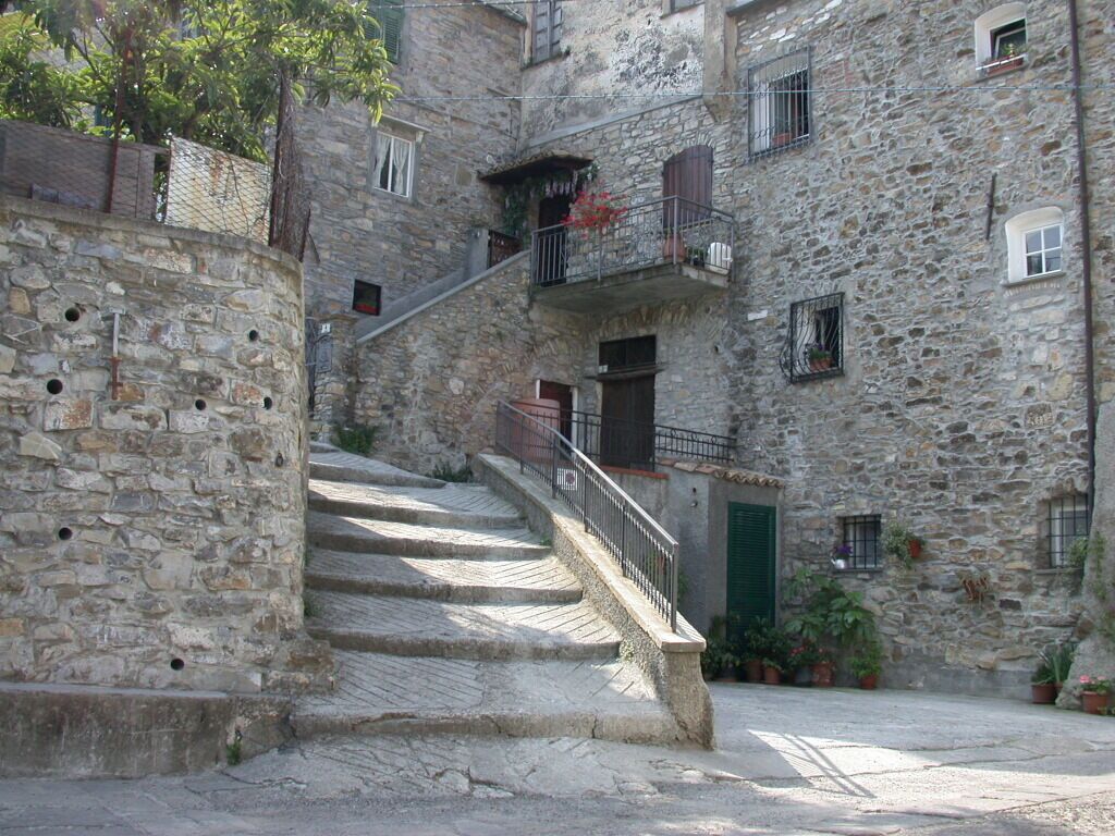 Un escalier en pierre menant à un bâtiment doté de balcons et de fenêtres.