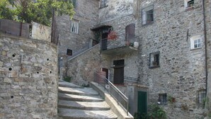 A stone staircase leading to a building with balconies and windows. - Ligurian rustico, surrounded by olive groves, 10 minutes from the sea. (Imperia)