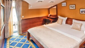 Ein Hotelzimmer mit einem großen Bett, einem Schreibtisch und einem Stuhl.