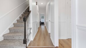 A hallway with a carpeted staircase and wooden flooring. - Two King Suites~ Downtown Rome~Walk to Broad (Rome)