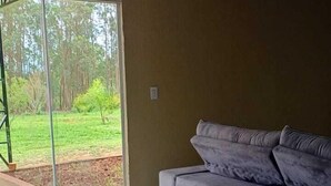 Une pièce spacieuse dotée d’une grande porte-fenêtre coulissante qui donne sur un patio.