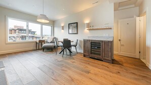 A spacious kitchen with a dining area, large windows, and a fireplace.