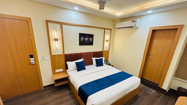 A hotel room with a bed, bedside tables, an air conditioning unit, and a ceiling fan. -  TRPOTELS THE ANANTA INN Near Old High Court Gwalior (Gwalior)