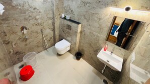 A bathroom with a shower, toilet, sink, and marble walls. -  TRPOTELS THE ANANTA INN Near Old High Court Gwalior (Gwalior)