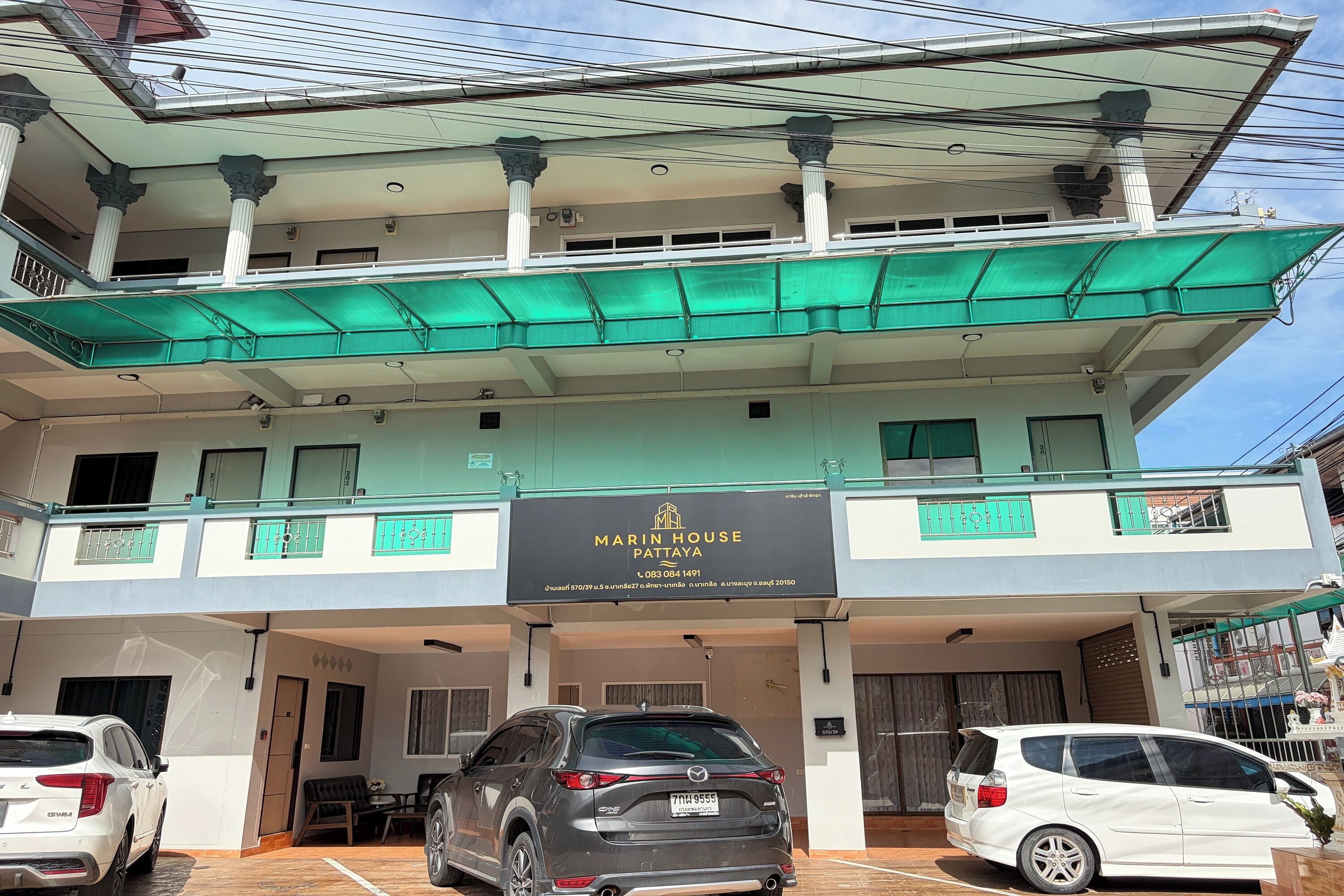 A multi-story building with a sign reading 'Marin House Pattaya.'