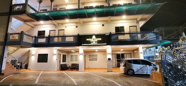 Un hôtel à plusieurs étages, sur lequel on peut lire l’inscription « MARRI HOUSE PATTAYA ».