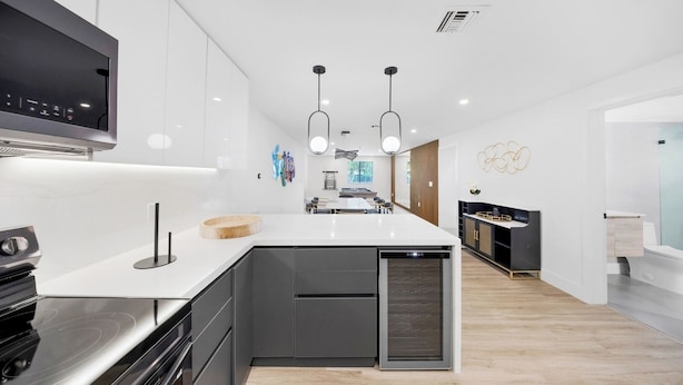 A modern kitchen with a central island, built-in appliances, and pendant lighting. - Design Dist villa:Pool,HotTub,billardandNespresso (Miami)