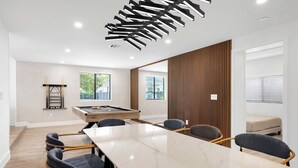 A modern conference room with a long table, six chairs, a pool table, and a wooden accent wall. - Design Dist villa:Pool,HotTub,billardandNespresso (Miami)