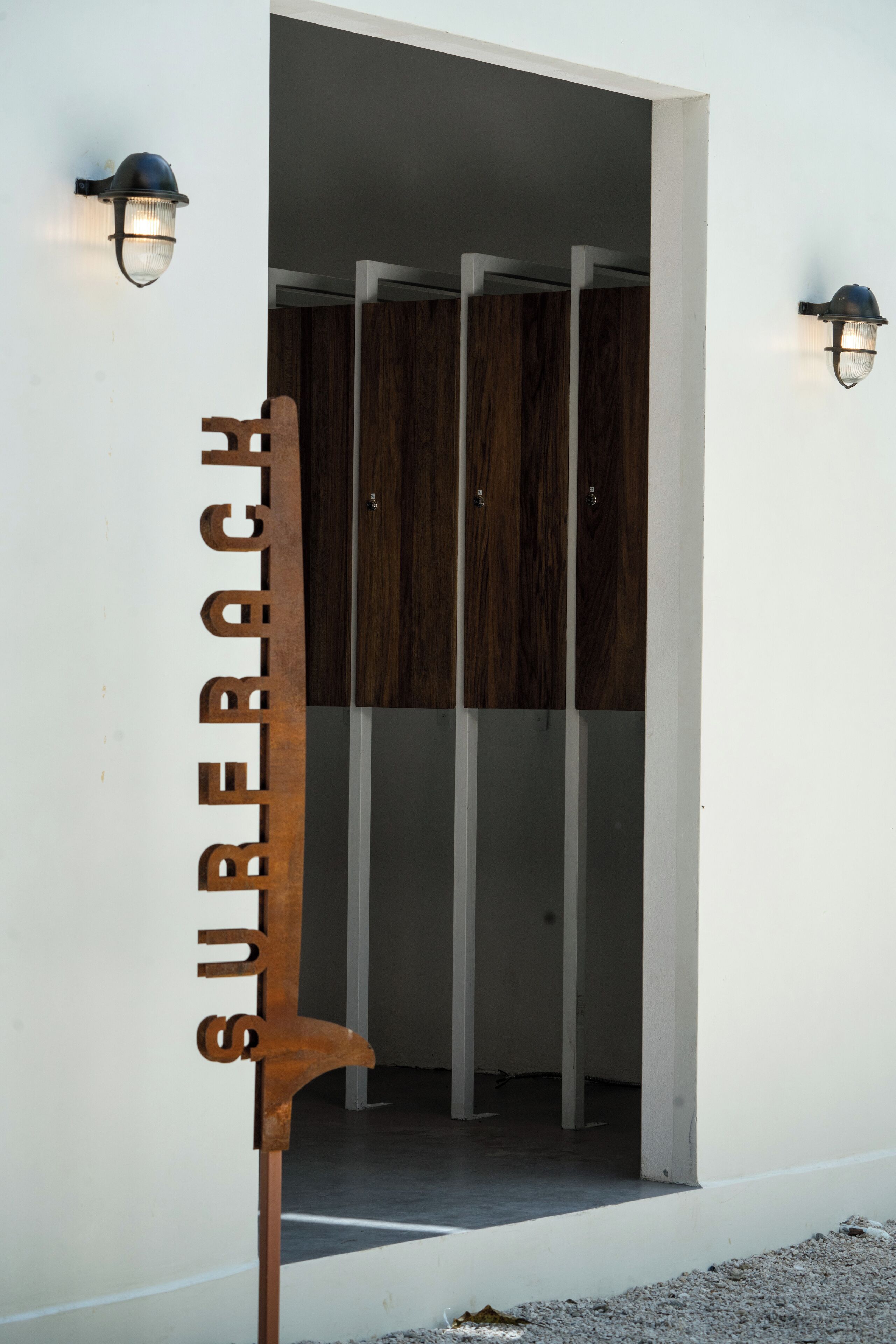 A modern entrance with a metal sign reading "SURECH" and wooden panels.