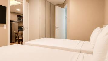 Une chambre d’hôtel avec un lit, un bureau et une kitchenette.