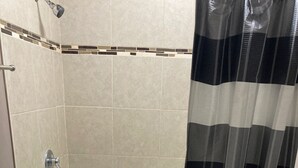 Kylpyhuone, jossa on kylpyamme, wc ja suihkuverho.