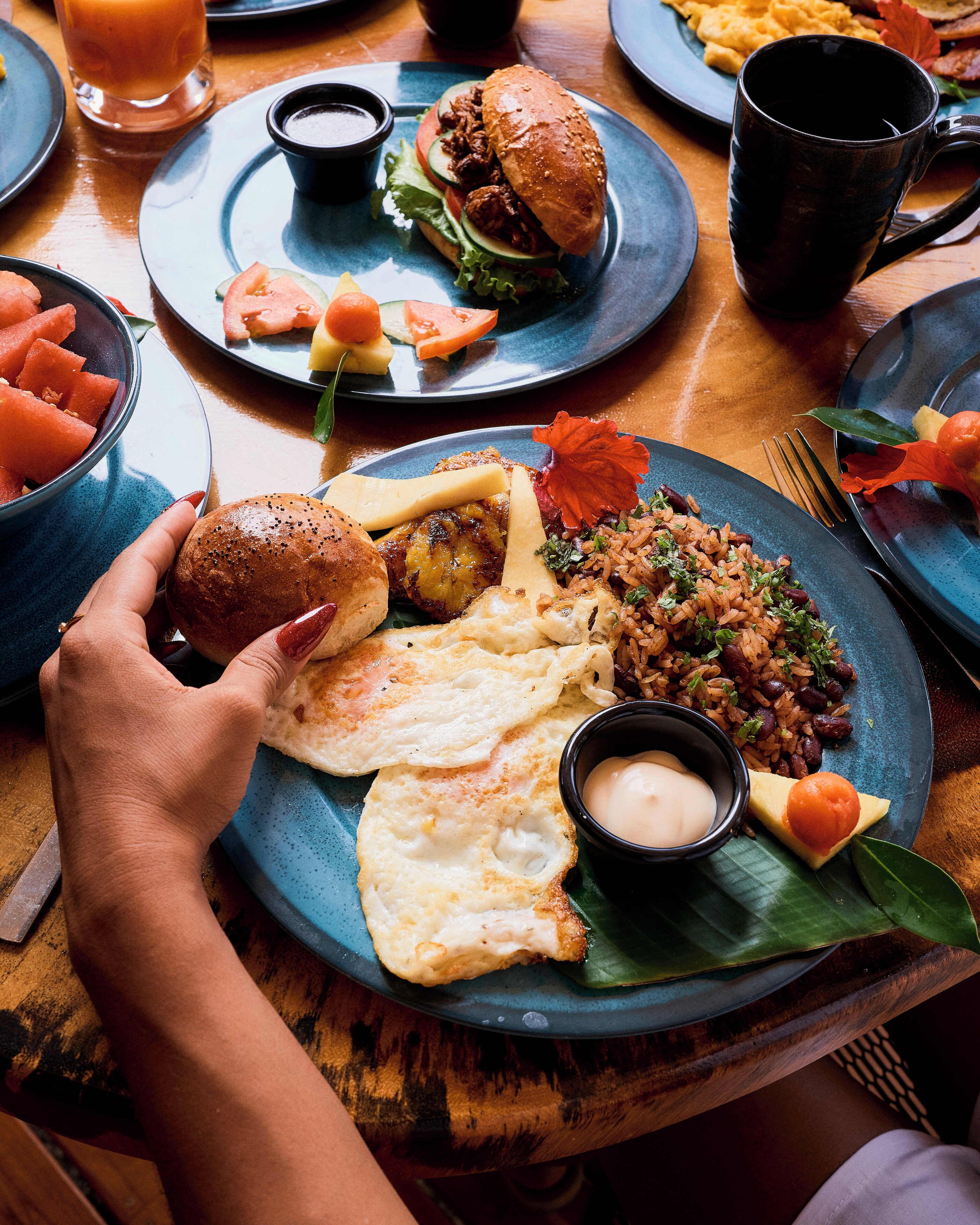 A dining table with various dishes including a plate with rice, eggs, and a bread roll.
