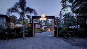 A resort entrance with a sign reading "EVIA LIFE RESORT" and a pathway leading to the buildings.