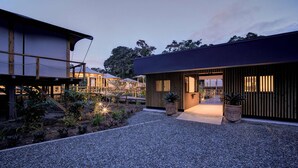 A modern building with a gravel pathway leading to a wooden entrance. - EVIA Life Resort (Puerto Viejo de Talamanca)