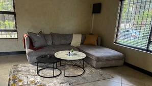 A modern living room with a grey sectional sofa, a small round table, and a patterned rug.