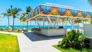 A beachside pavilion with a colorful geometric design, seating area, and a view of the ocean. - Garza Blanca Resort and Spa (Punta Sam)