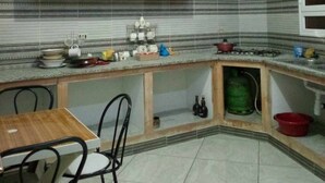 A kitchen with a dining area, featuring cabinets, a countertop, and a window. - Dar Bilel a beautiful place  (Tozeur)