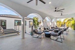 A covered outdoor area with seating, a staircase, and a view of the surrounding landscape. - Private Ultra-Luxury 10 Bedroom | 14 Bath Mansion (Tampa)