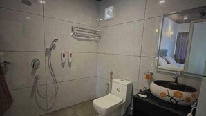 Une salle de bain moderne équipée de toilettes, d’un bidet et d’une douche.