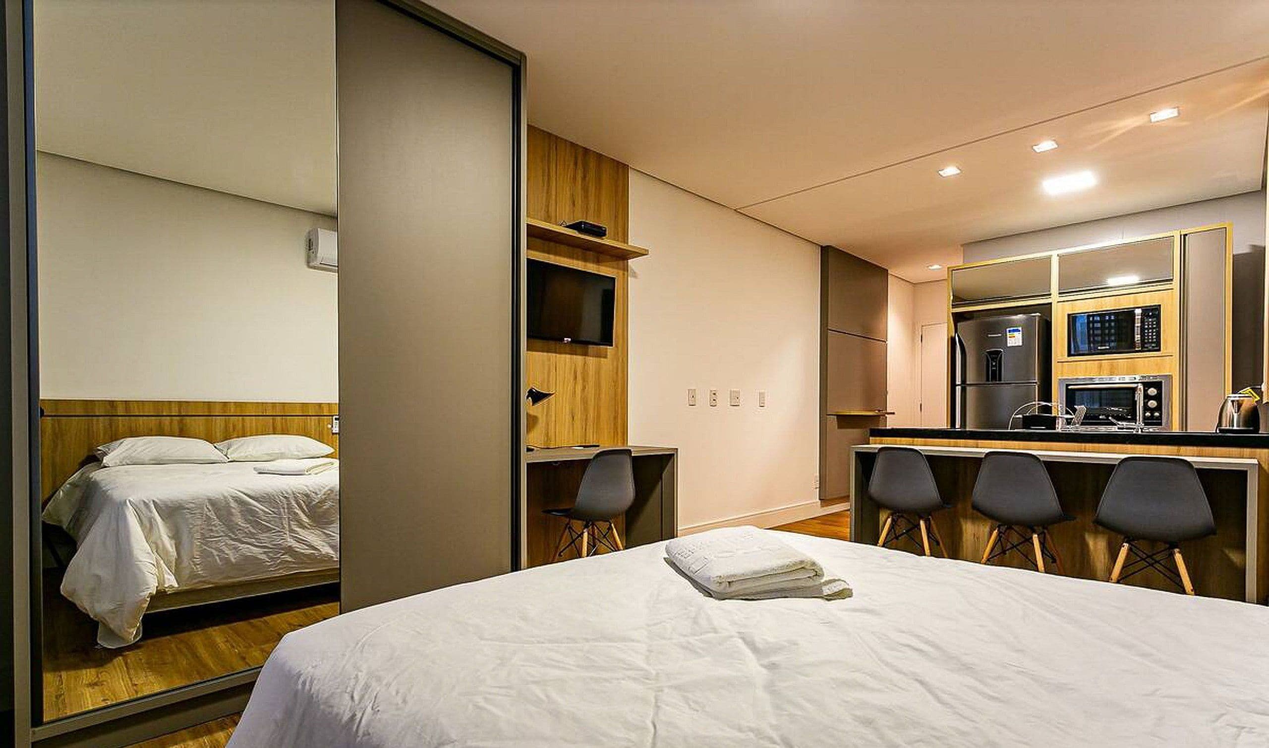 Une chambre d’hôtel équipée d’un lit, d’un bureau, d’une chaise, d’un four à micro-ondes et d’un réfrigérateur.