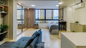 Une chambre d’hôtel moderne, dotée d’un grand lit, d’un canapé, d’un bureau et offrant une vue sur la ville.