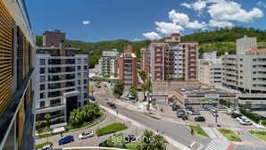 Un quartier urbain moderne avec des immeubles à plusieurs étages, une rue principale et un parking.