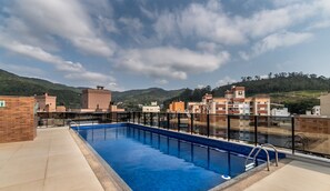A rooftop swimming pool with a clear view of surrounding buildings and hills.