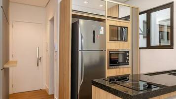 A modern kitchen with a built-in refrigerator, oven, and microwave.