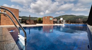 A swimming pool with a clear view of the surrounding buildings and a mountainous landscape in the background. - SSG Estúdios próximos a UFSC em Florianópolis (Florianópolis)