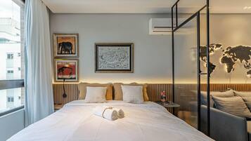 Habitación de hotel con una cama grande, un mural de mapa mundial y obras de arte que representan Zambia.