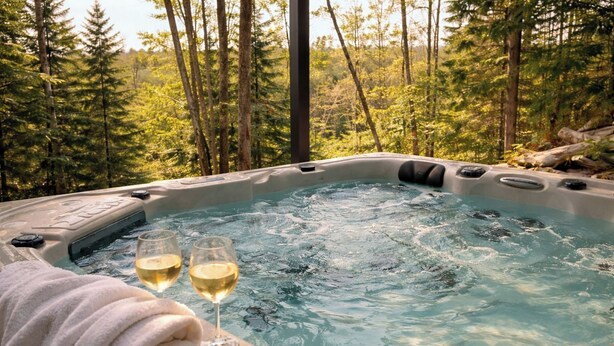 A hot tub surrounded by a forest. - Havre du Mont * New Construction (st-come)