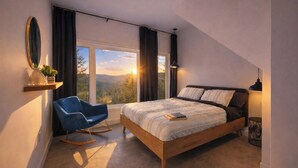 A bedroom with a large bed, a chair, a mirror, and a view of the outdoors. - Havre du Mont * New Construction (st-come)