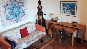Una sala de estar con sofá, mesa de centro y comedor con sillas y una mesa.