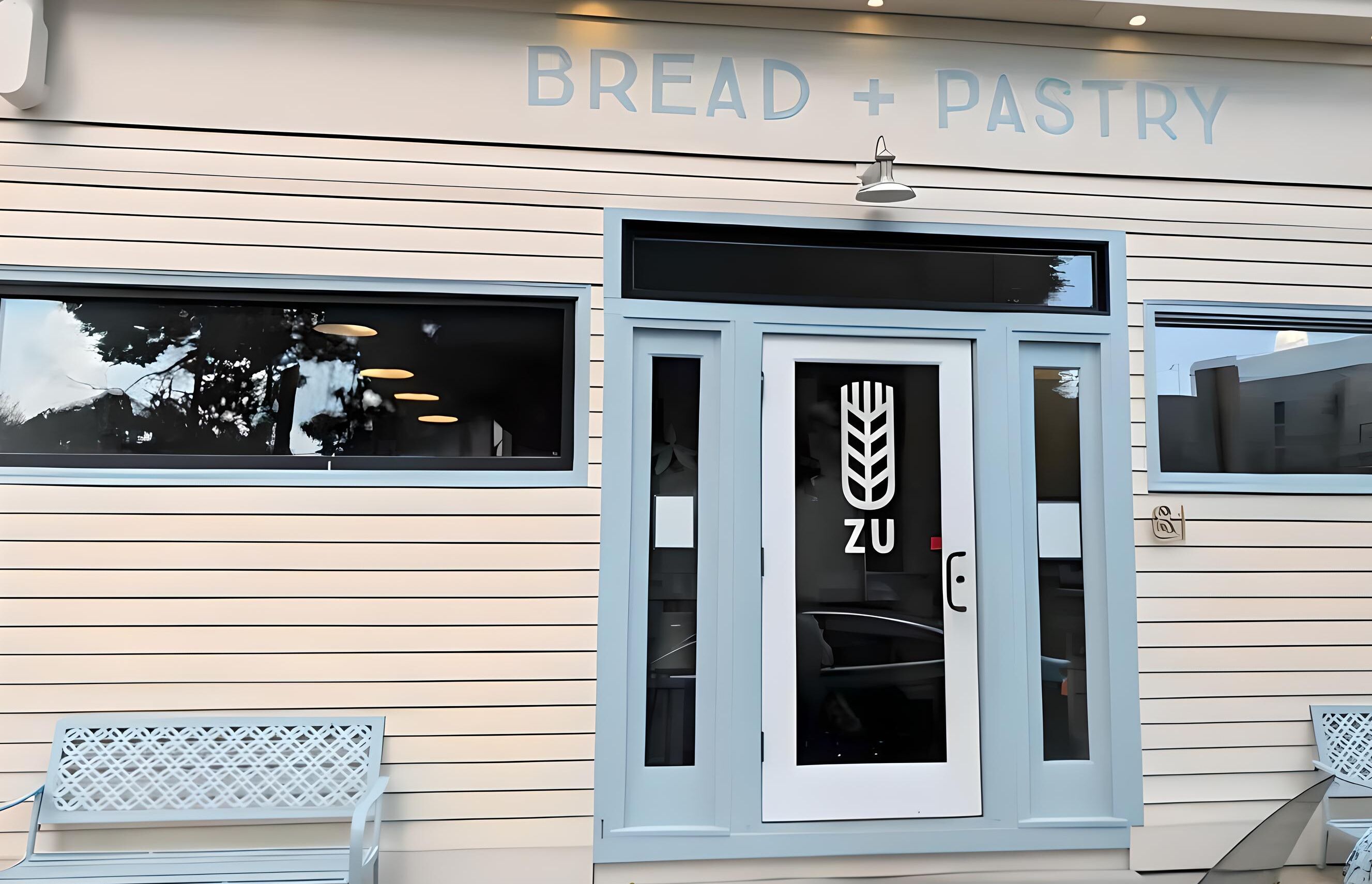 Une devanture de magasin avec une enseigne indiquant « PAIN + PÂTISSERIE » et un logo représentant un épi de blé.