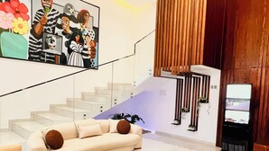 Una sala de estar moderna con un sofá, una mesa de centro y una escalera que lleva a un rellano de madera.