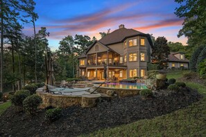 A large, multi-story house with a swimming pool, surrounded by a landscaped garden and trees. - Livin' Large Lake Norman Estate w/ Pool, Dock, Game Room & Scenic Views (Mooresville)