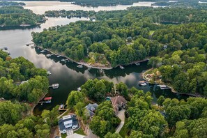 An aerial view of a lakeside property with docks, boats, and lush greenery. - Livin' Large Lake Norman Estate w/ Pool, Dock, Game Room & Scenic Views (Mooresville)