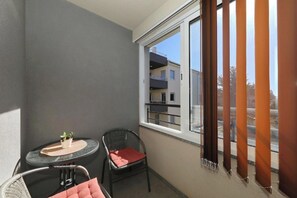 A balcony with a table, two chairs, and a potted plant. - Apartment Donat  (Zadar)