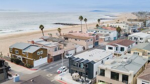 Zona residencial costera con casas, una playa y una señal de parada.