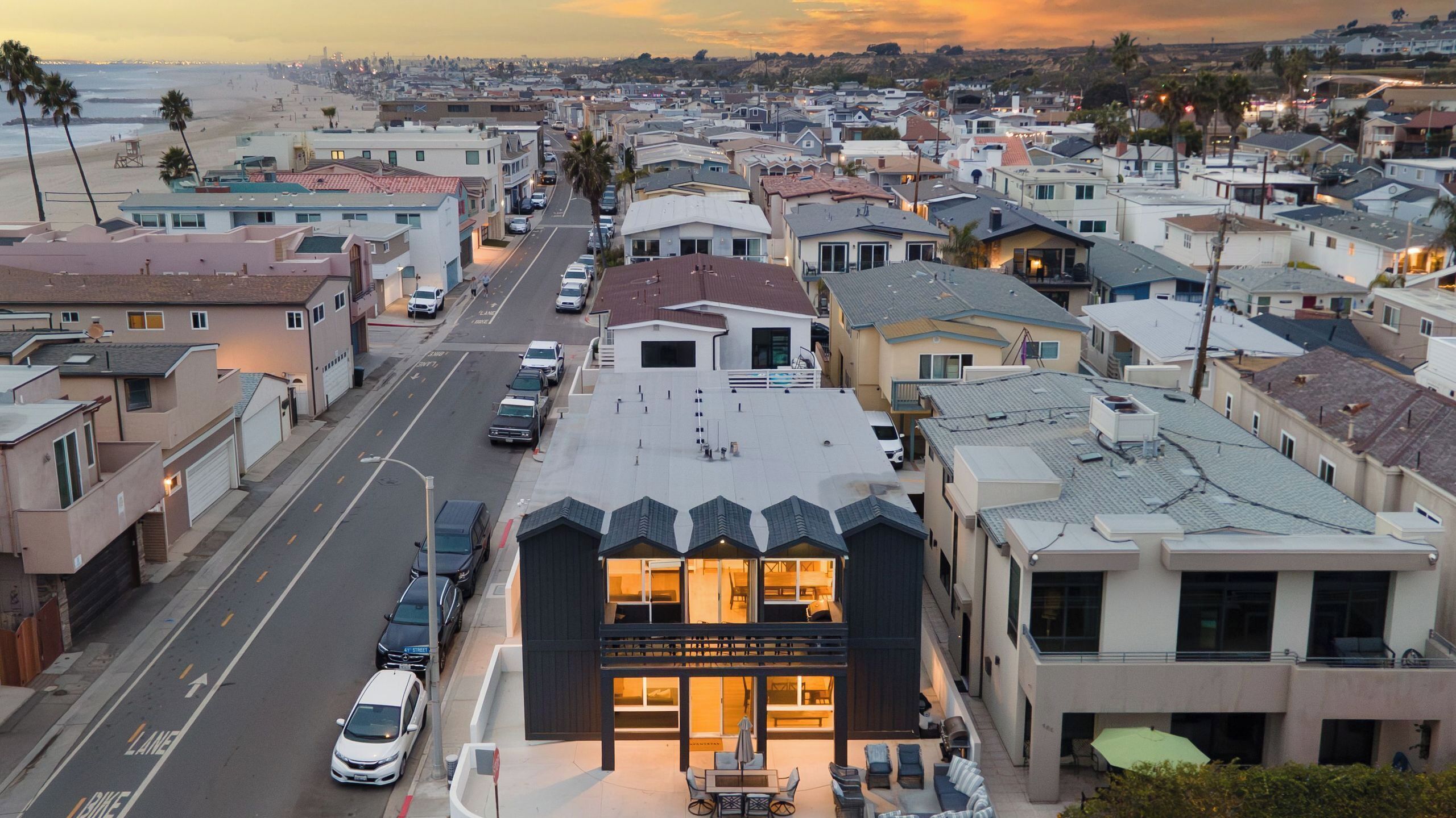 A residential area with a street, houses, and a building with a balcony.