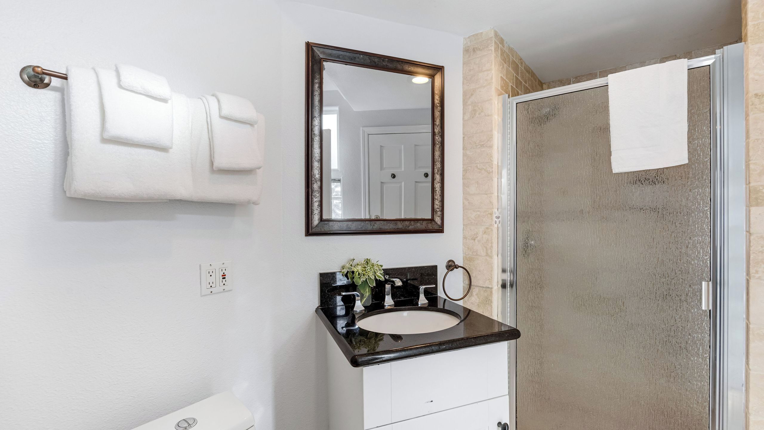 A bathroom with a white sink, a mirror, and a towel rack.