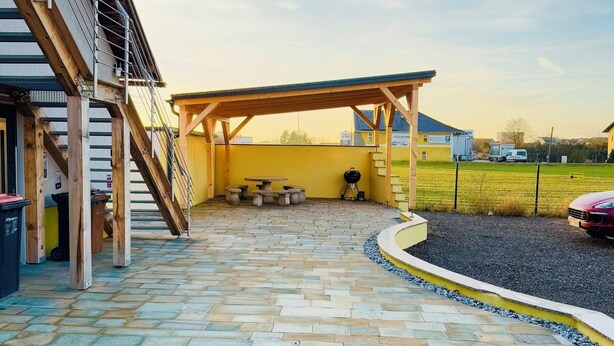 A patio area with a pergola, outdoor seating, and a barbecue grill. - YS Apartments e.U. (Marchtrenk)