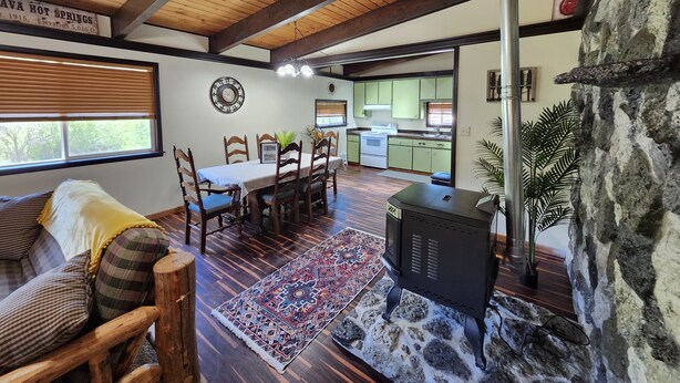 A cozy living room with a dining area, a kitchen, and a stone wall. - 2 Cabins on 4 private acres! Sleeps up to 12, with options for more, if camping! (Lava Hot Springs)