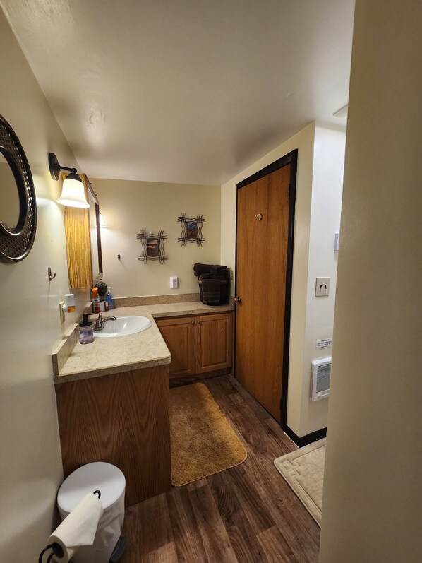 A compact bathroom with a sink, mirror, and toilet.