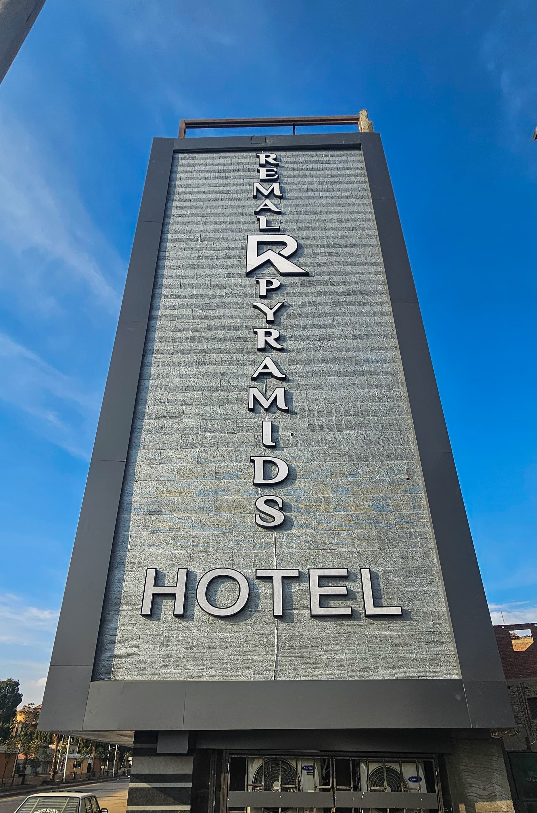 Ein hohes Gebäude mit dem Schriftzug "Emerald Pyramids Hotel" an der Fassade.