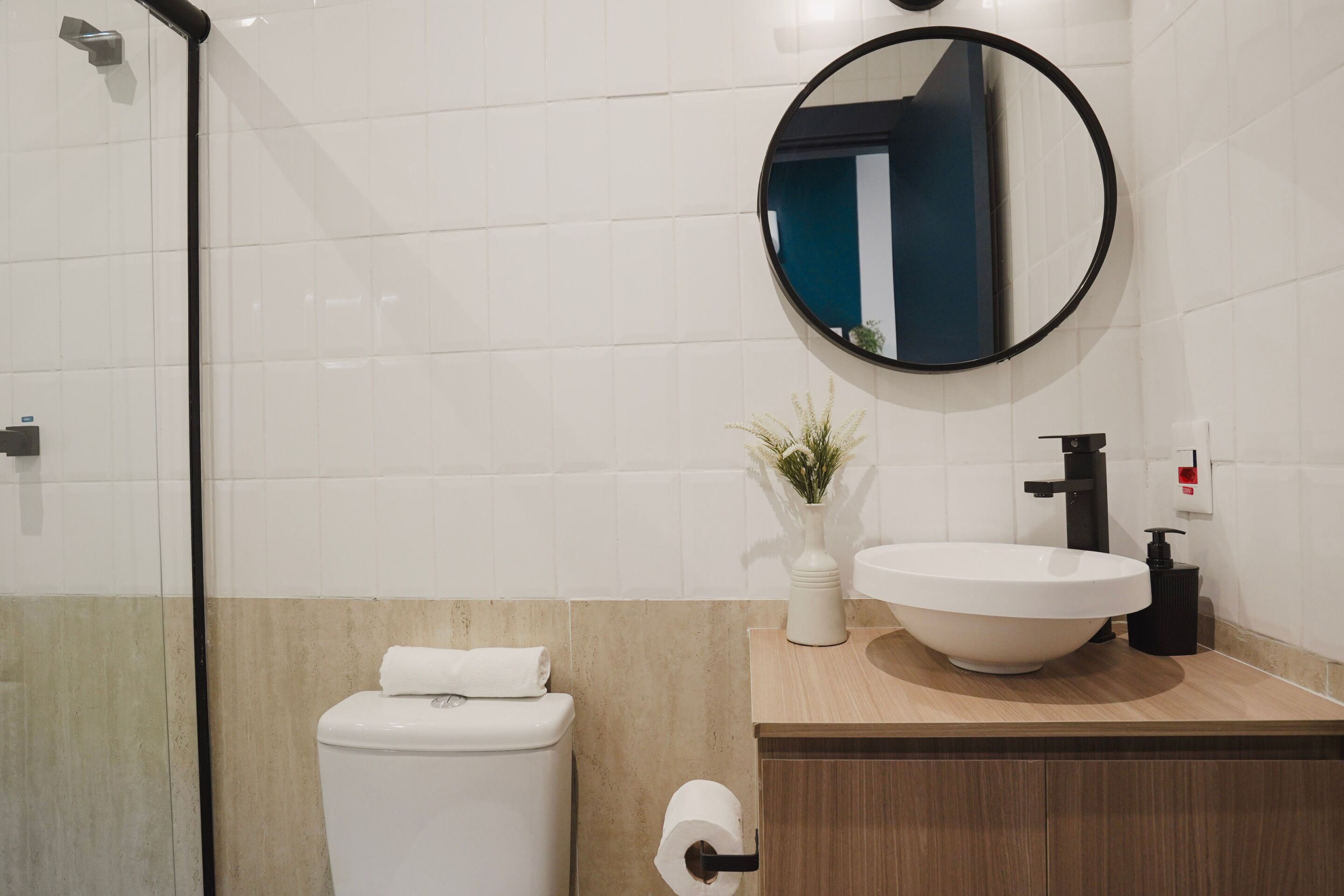 A modern bathroom with a toilet, sink, and mirror.