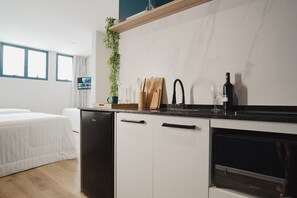 Una cocina moderna con lavavajillas integrado, una copa de vino y una planta en la encimera.