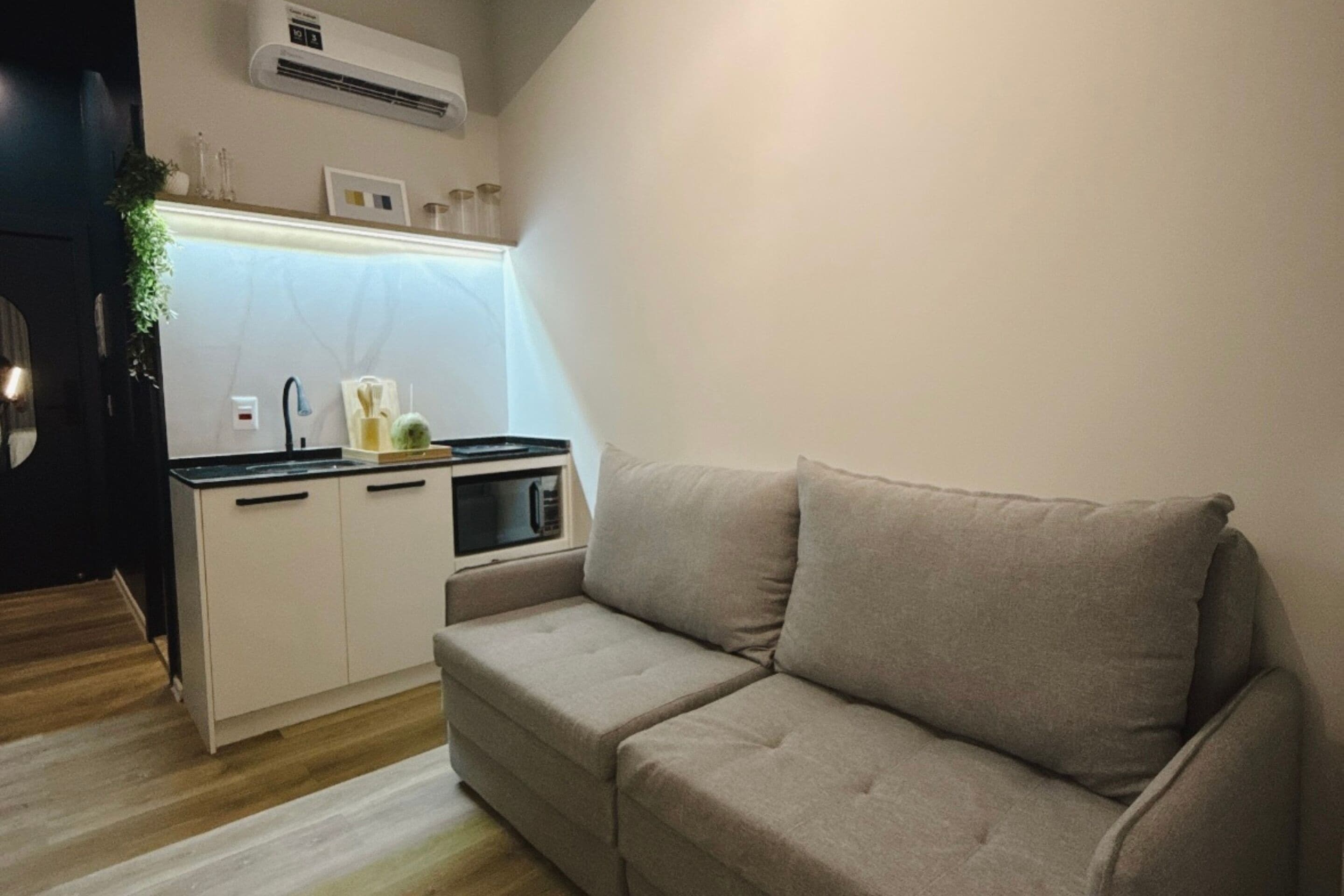 A compact living space with a kitchenette, a sofa, and a small dining table.