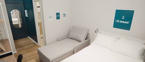 Une chambre d’hôtel comprenant un lit, un canapé, un bureau avec une chaise et un miroir.